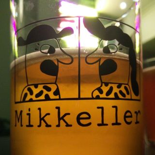 A photo of this beer’s amber colour of the pint glass’s logo, Mikkeller