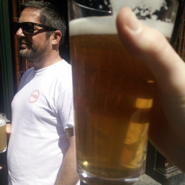 A photo of this beer, out of focus, and my good friend James in the background and in focus also enjoying a beer on a sunny May afternoon